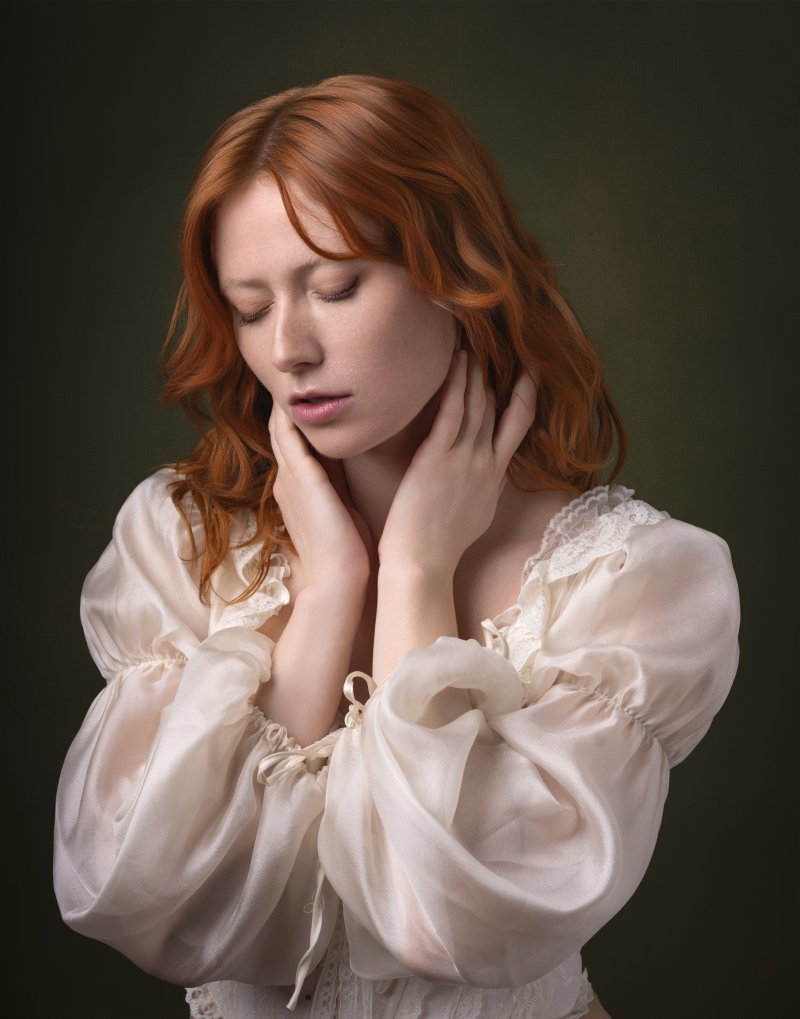 Woman with red hair and vintage clothes posing in studio