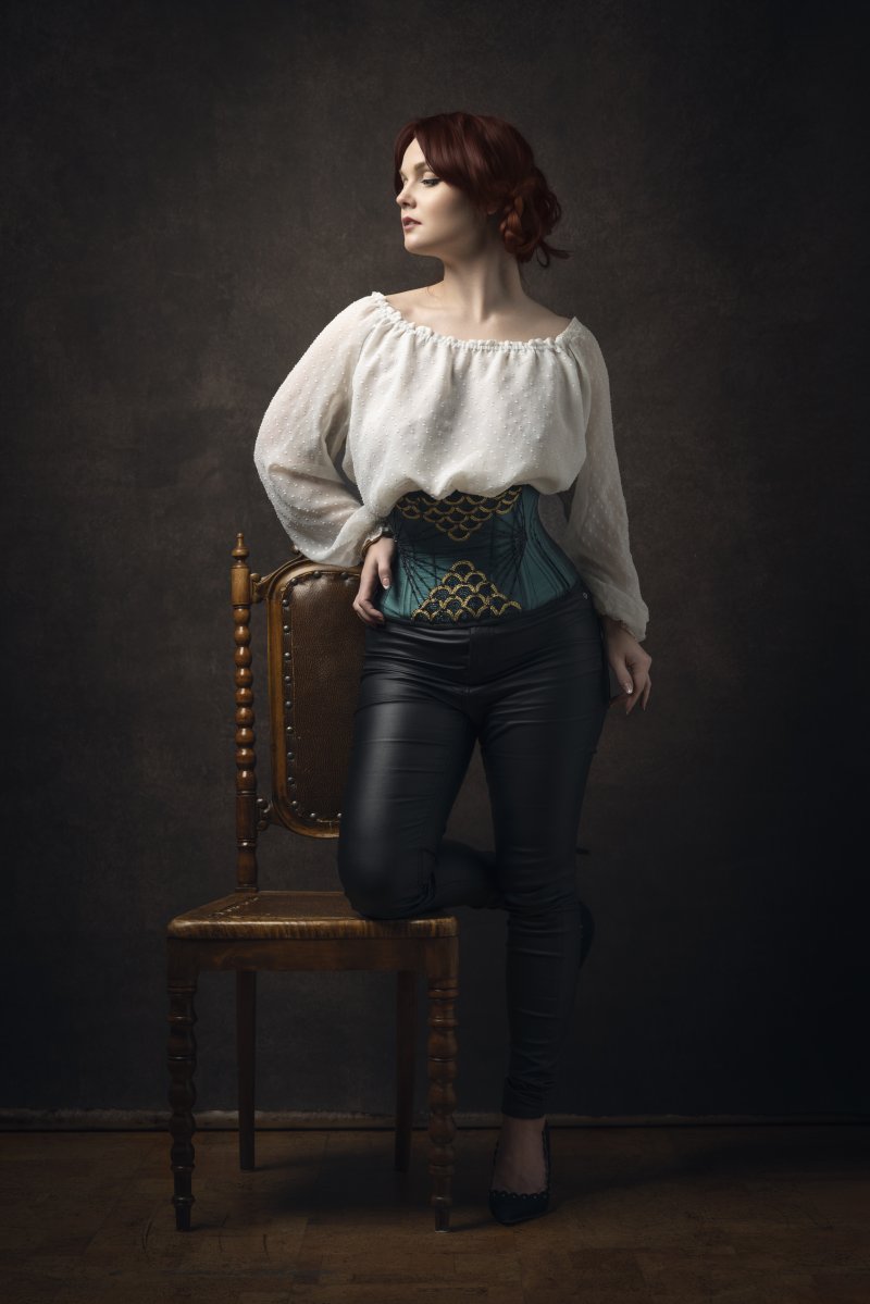 Woman posing in studio wearing vintage looking clothes